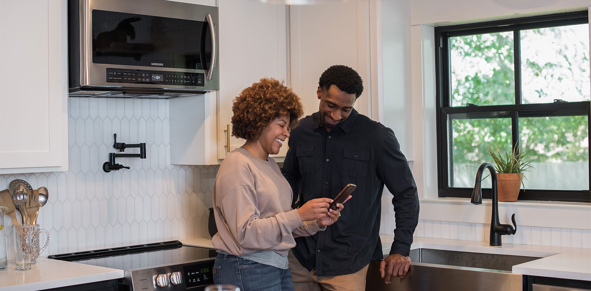 Couple looking at a thermostat app on there phone